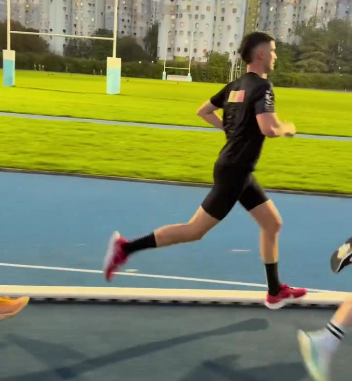 Coureur du club en pleine foulée sur la piste bleue du stade Jean Guimier